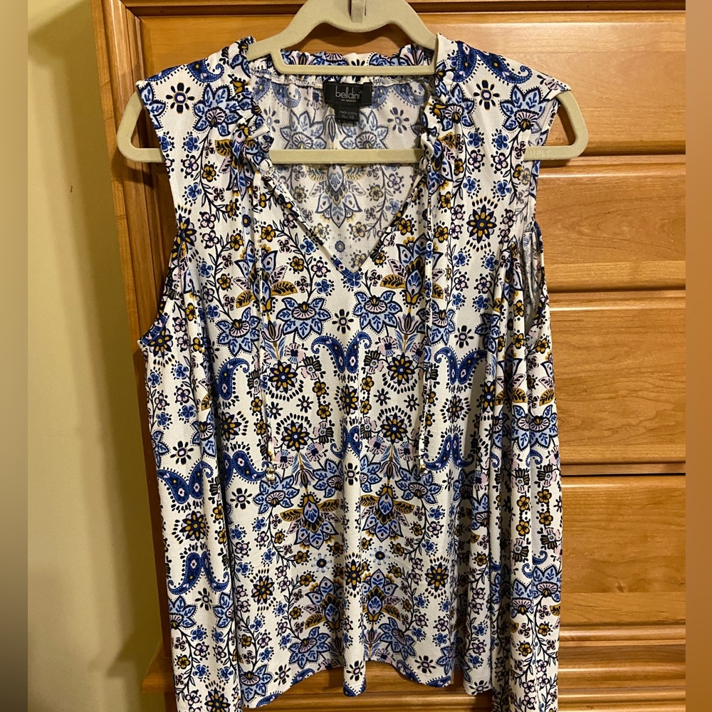 Patterned cold shoulder top with long sleeves; elastic gathering at wrist.